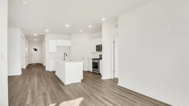 a view of a kitchen with wooden floor and a sink