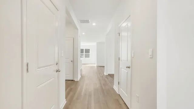 a view of a hallway with wooden floor