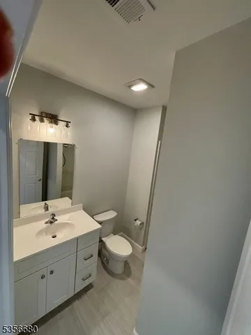 a bathroom with a double vanity sink toilet and mirror