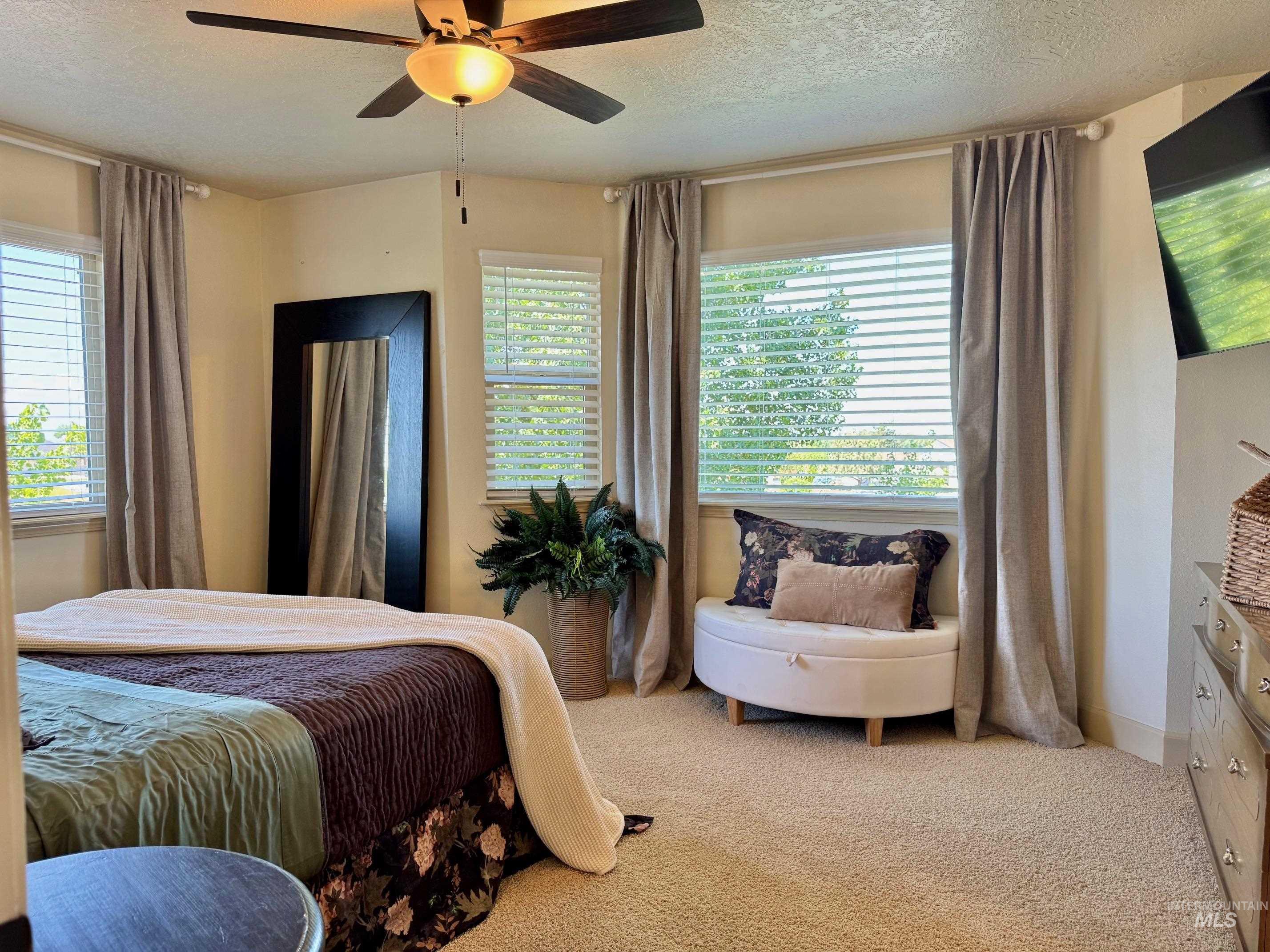 9299 Kemp Road Middleton, ID 83644 - Photo 24 of 50 Carpeted room featuring a ceiling fan with integrated lighting, multiple windows with blinds and drapes, and neutral wall tones
