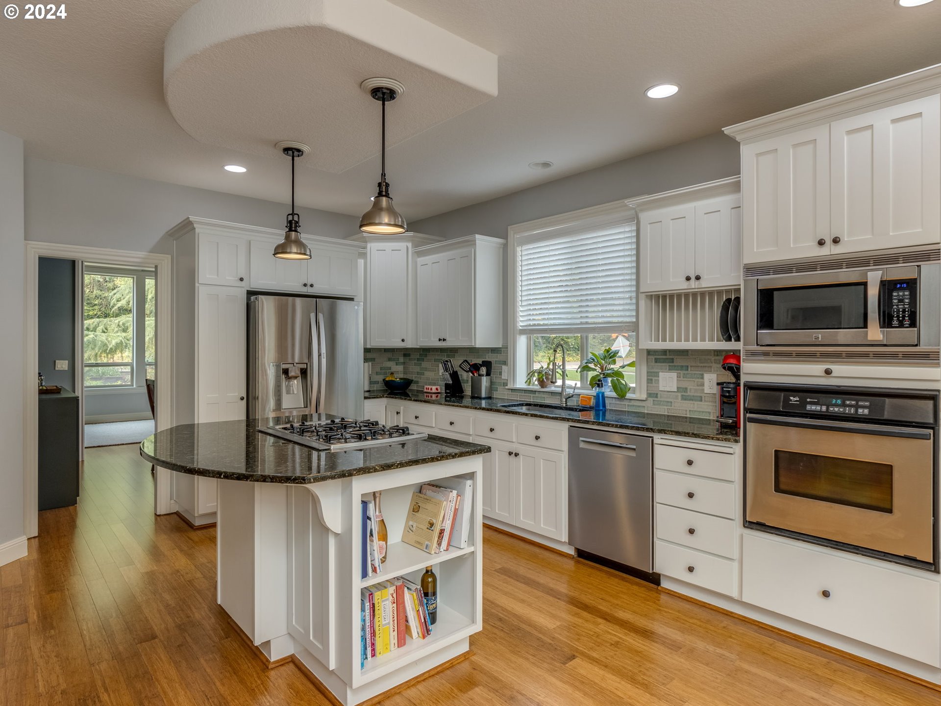 5316 Lower Drive Lake Oswego, OR 97035 - Photo 6 of 25 a kitchen with kitchen island granite countertop a stove a sink a center island and wooden floor