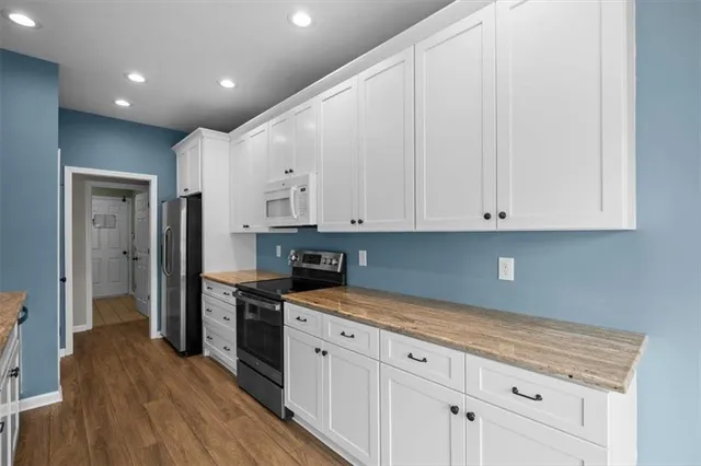 a kitchen with stainless steel appliances granite countertop a sink and wooden cabinets