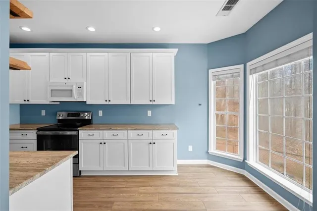 a view of a kitchen with wooden floor and windows