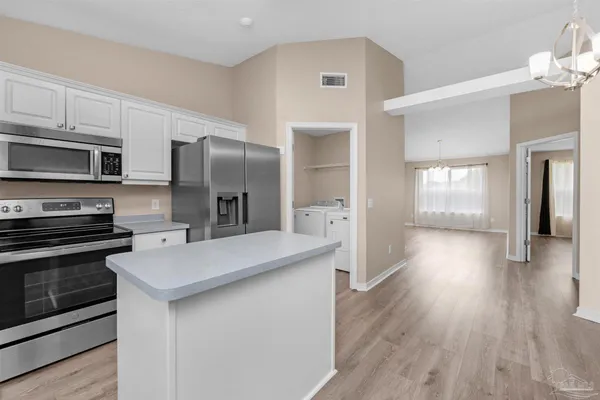 a kitchen with stainless steel appliances a refrigerator and a stove top oven