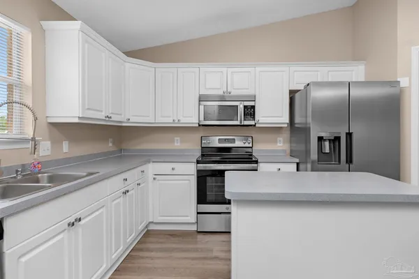 a kitchen with stainless steel appliances a refrigerator sink and microwave