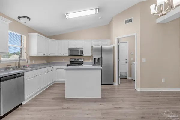 a kitchen with granite countertop a refrigerator stove top oven and sink