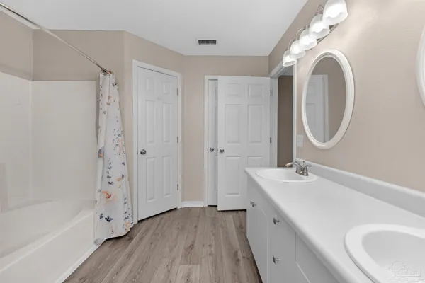 a bathroom with a double vanity sink mirror and shower