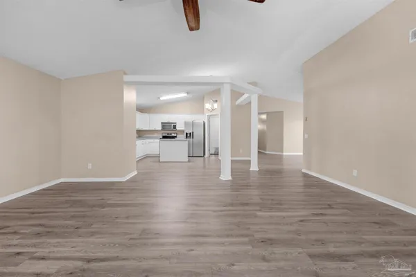 a view of an empty room with wooden floor