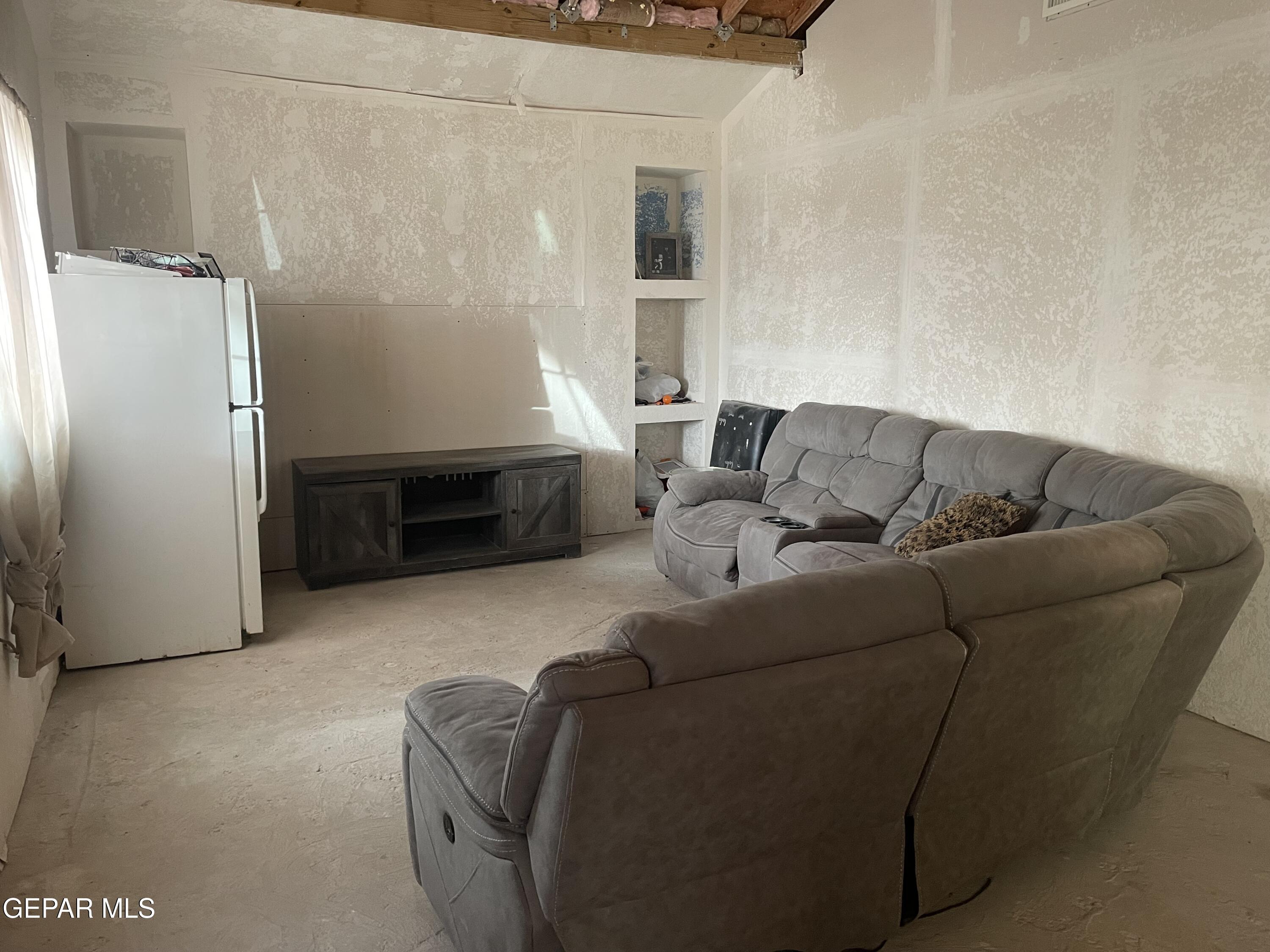 966 Traymore Road El Paso, TX 79928 - Photo 6 of 27 a living room with a couch and a refrigerator