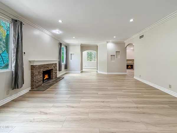 a view of a livingroom with wooden floor and a fireplace