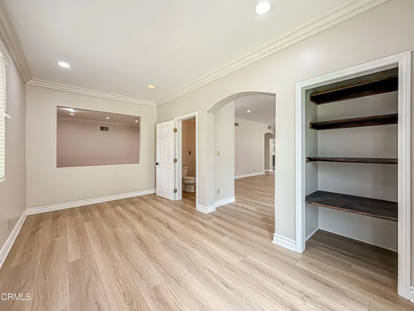 a view of empty room with wooden floor and entryway