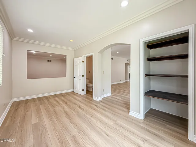 a view of empty room with wooden floor and entryway