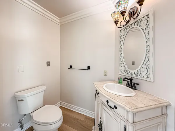 a bathroom with a toilet sink vanity and mirror