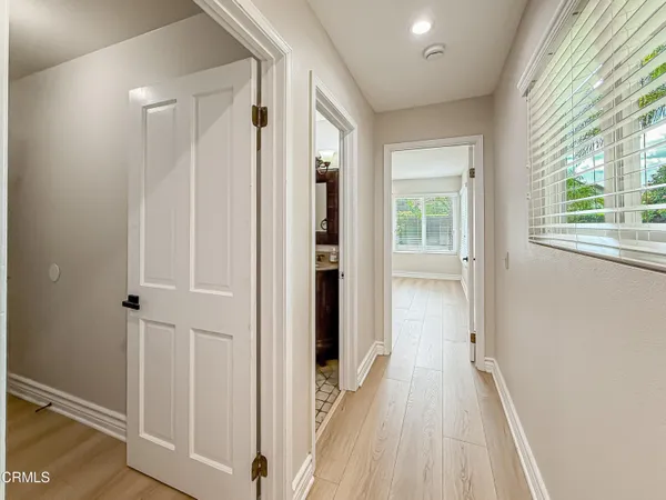 a view of a hallway with wooden floor and windows