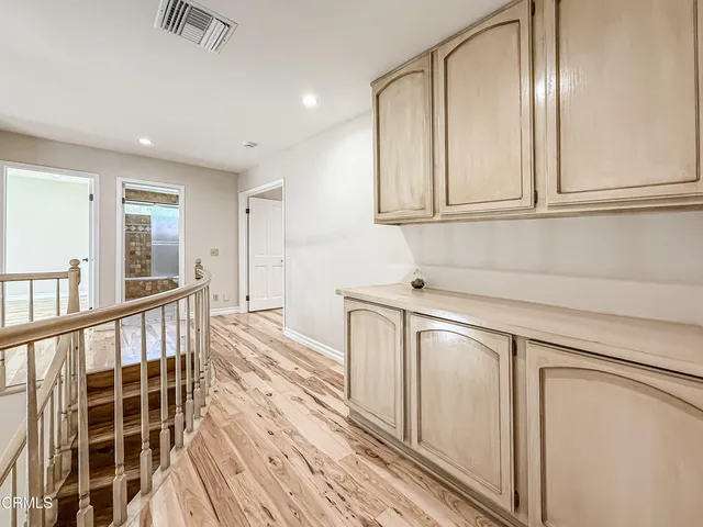 a view of a kitchen with wooden floor and cabinets