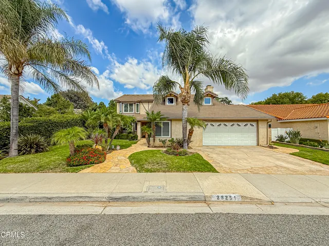 front view of a house with a yard and potted plants