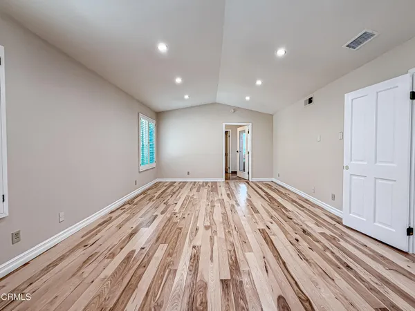 a view of empty room with wooden floor