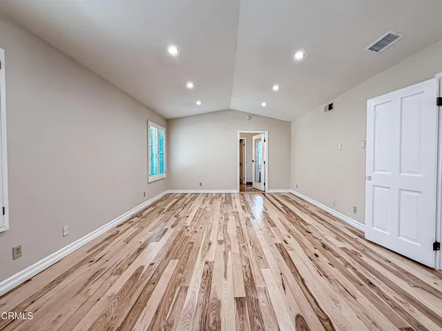 a view of empty room with wooden floor