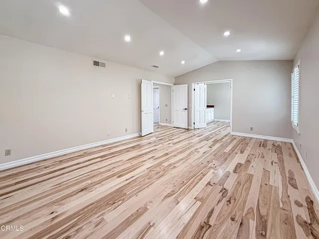 a view of empty room with wooden floor