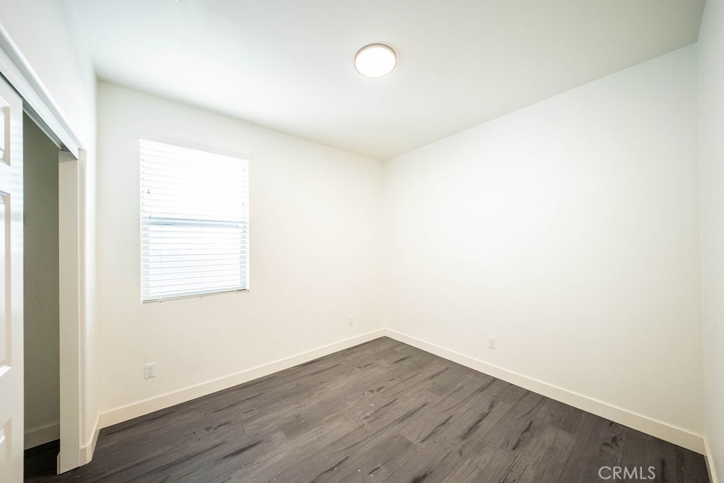 1928 Ray Abril Jr Lane Colton, CA 92324 - Photo 14 of 33 an empty room with wooden floor and windows