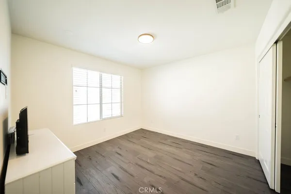 a view of a kitchen with wooden floor and white walls