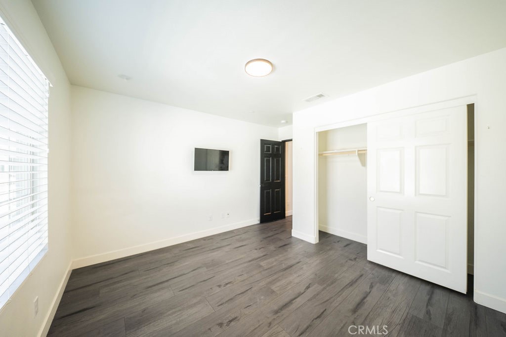 1928 Ray Abril Jr Lane Colton, CA 92324 - Photo 23 of 33 an empty room with wooden floor and windows