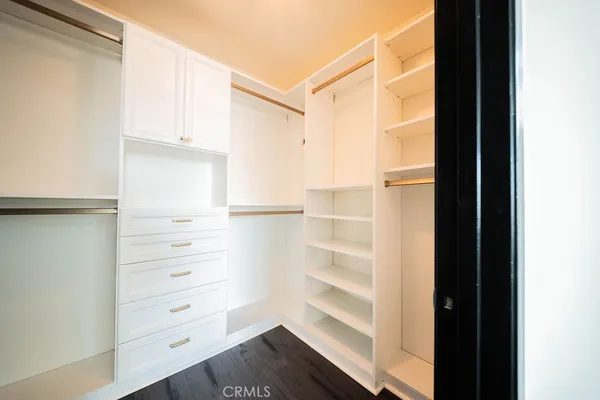 a view of walk in closet with empty racks