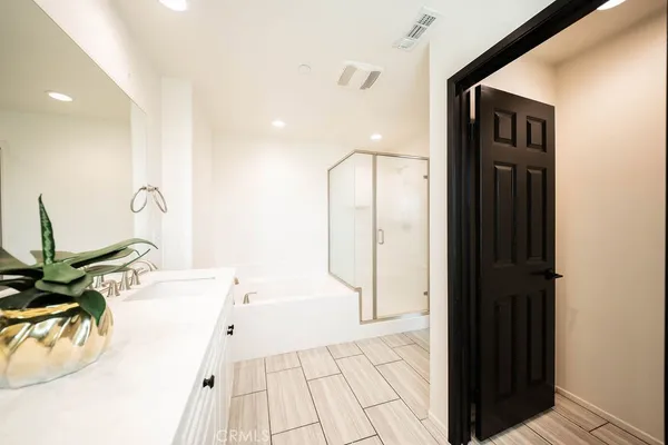 a bathroom with a double vanity sink mirror and bathtub