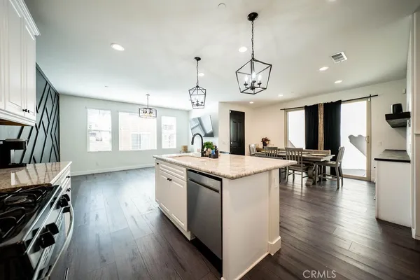 a kitchen with stainless steel appliances granite countertop wooden floors and white cabinets