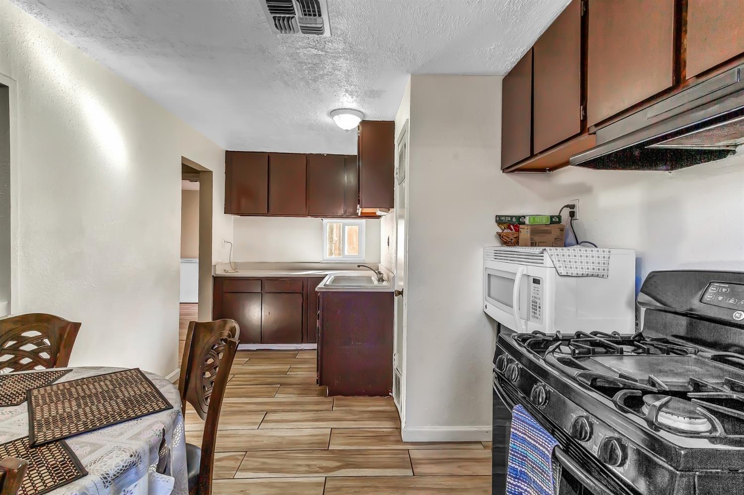 320 Acacia Street Lodi, CA 95240 - Photo 10 of 31 a kitchen with granite countertop a stove and a refrigerator