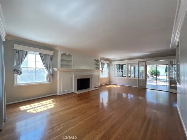 an empty room with wooden floor and fireplace