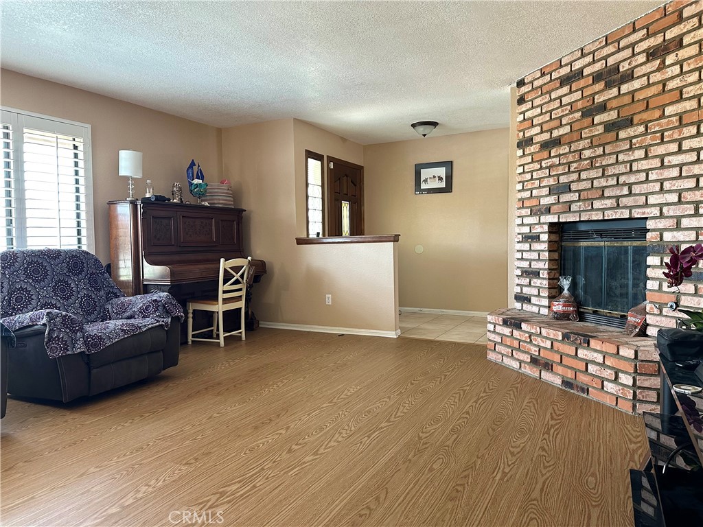 18143 Kalin Ranch Drive Victorville, CA 92395 - Photo 11 of 28 a living room with furniture a fireplace and a flat screen tv