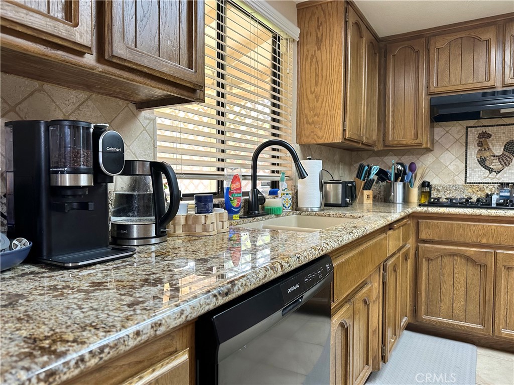 18143 Kalin Ranch Drive Victorville, CA 92395 - Photo 13 of 28 a kitchen with stainless steel appliances granite countertop a sink a stove and cabinets