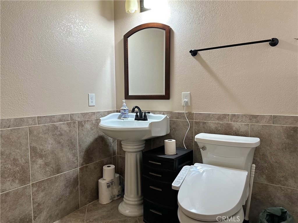 18143 Kalin Ranch Drive Victorville, CA 92395 - Photo 19 of 28 a bathroom with a toilet a sink and a mirror