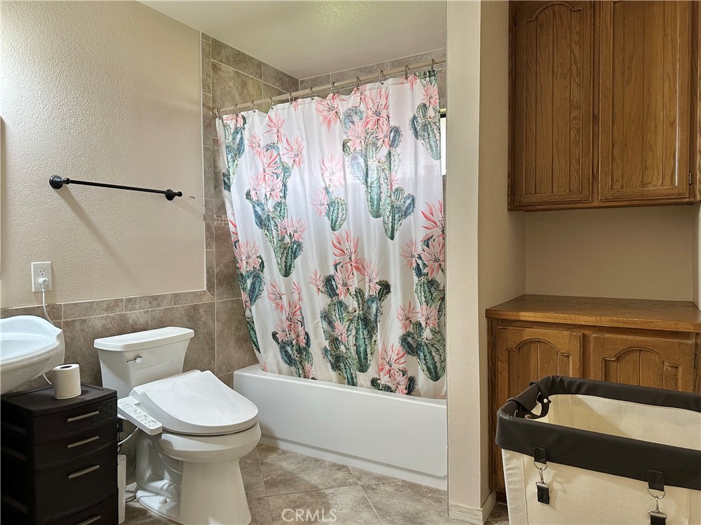 18143 Kalin Ranch Drive Victorville, CA 92395 - Photo 20 of 28 a white toilet sitting next to a bathroom sink and tub