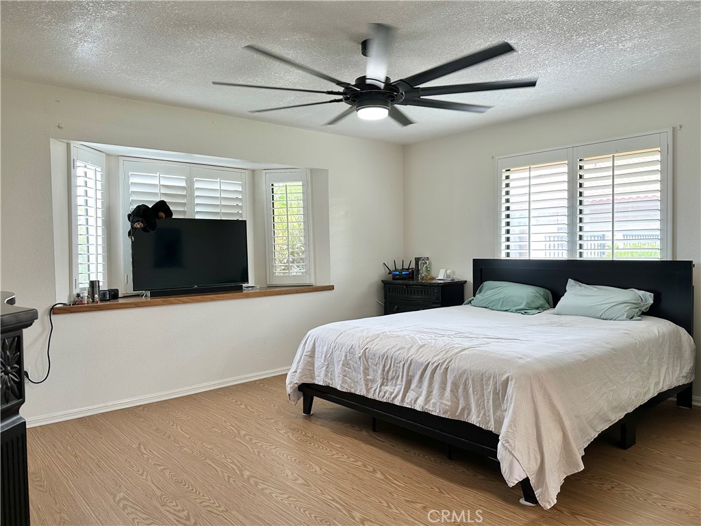 18143 Kalin Ranch Drive Victorville, CA 92395 - Photo 22 of 28 a bedroom with a large bed and a chandelier