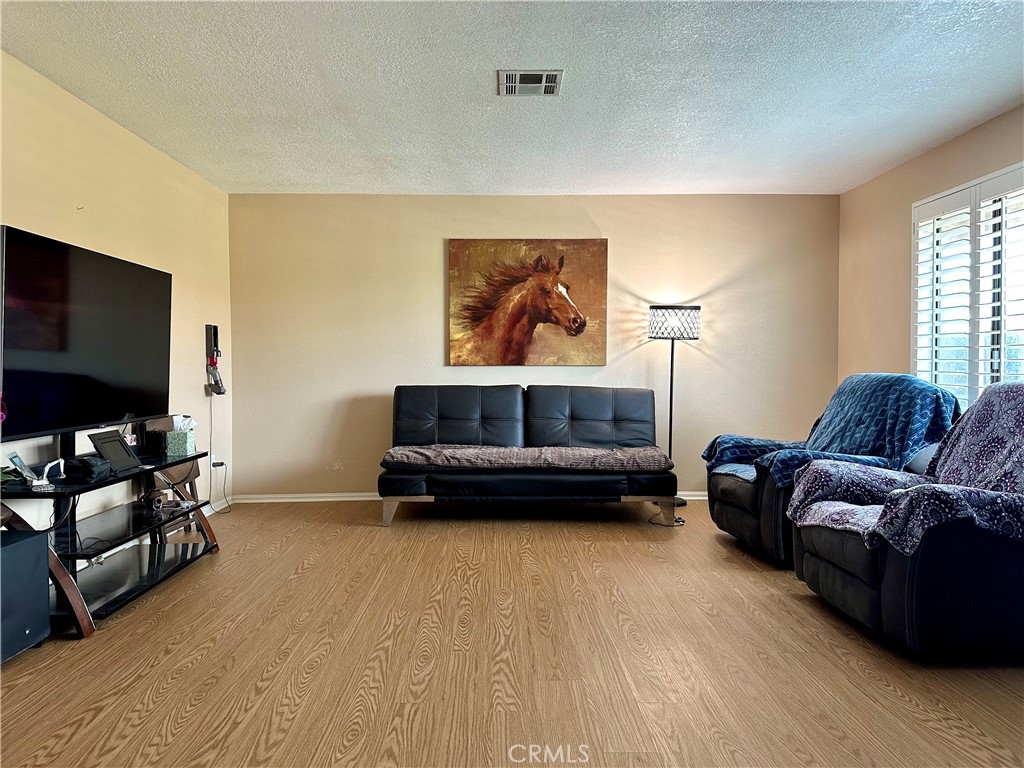 18143 Kalin Ranch Drive Victorville, CA 92395 - Photo 9 of 28 a living room with furniture and a flat screen tv
