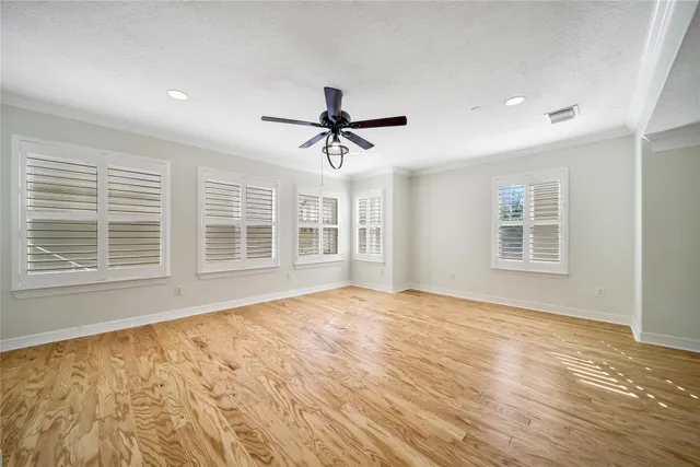 a view of an empty room with a window and a ceiling fan