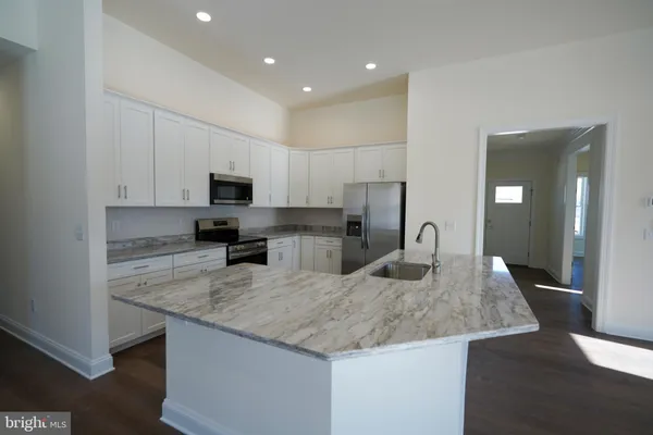 a kitchen with granite countertop kitchen island a sink appliances and cabinets