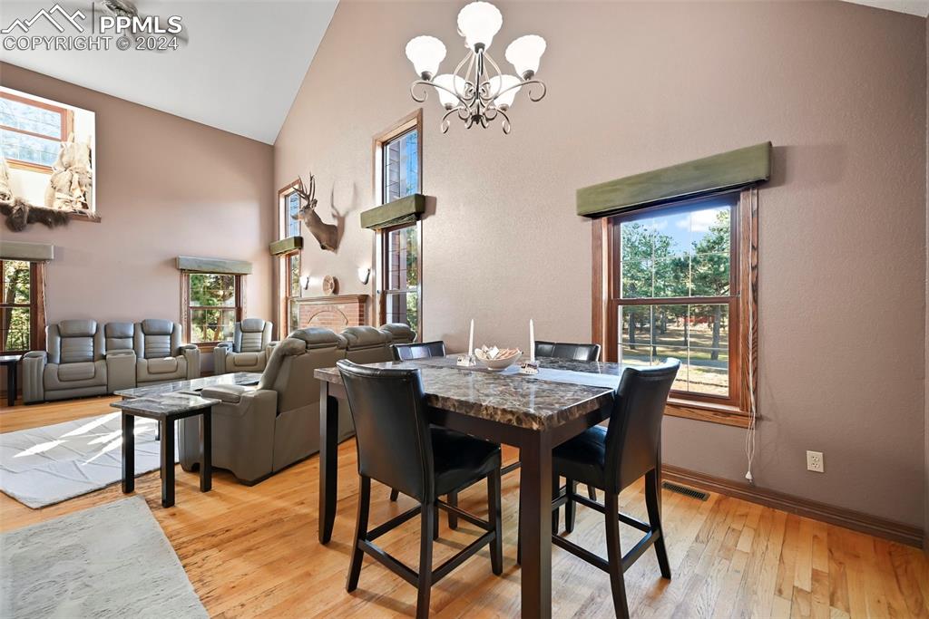 14560 Spiritwood Loop Elbert, CO 80106 - Photo 20 of 44 a view of a dining room with furniture a chandelier and wooden floor