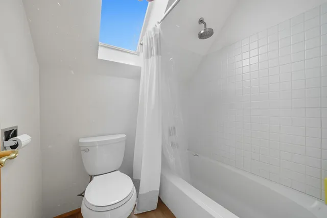 a white toilet sitting next to a bath tub
