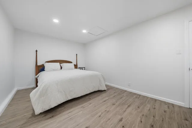a bedroom with a bed and wooden floor
