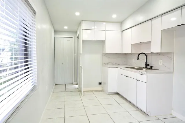 a kitchen with a sink a refrigerator and cabinets