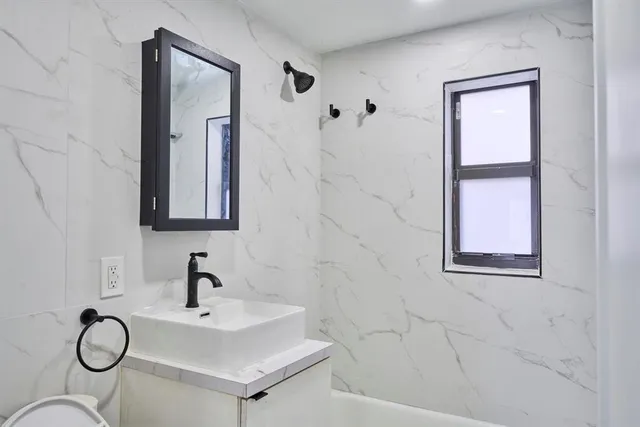 a bathroom with a sink and mirror with window