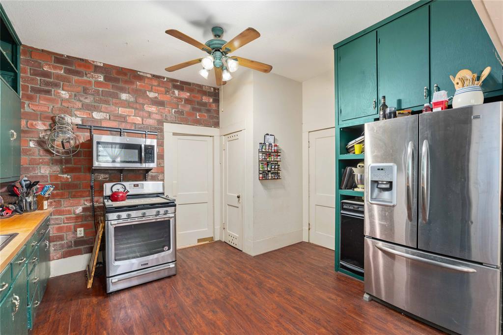 701 4th Street Goldthwaite, TX 76844 - Photo 11 of 32 a kitchen with stainless steel appliances a refrigerator and a stove top oven