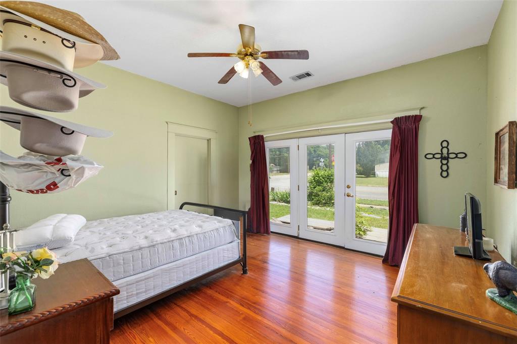701 4th Street Goldthwaite, TX 76844 - Photo 20 of 32 a bedroom with a bed and wooden floor