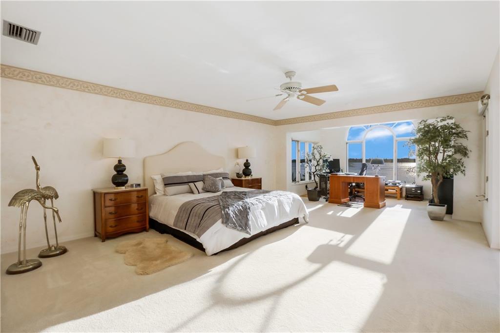 171 South River Road Stuart, FL 34996 - Photo 51 of 68 a spacious bedroom with a bed and a chandelier