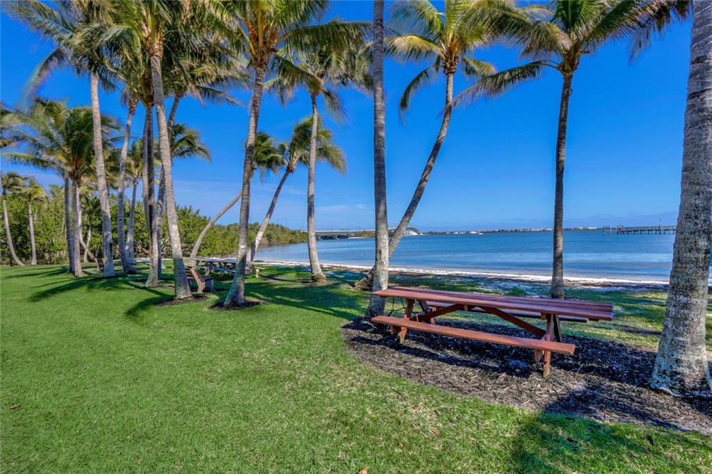 171 South River Road Stuart, FL 34996 - Photo 63 of 68 a view of backyard with lawn chairs wooden fence and palm trees