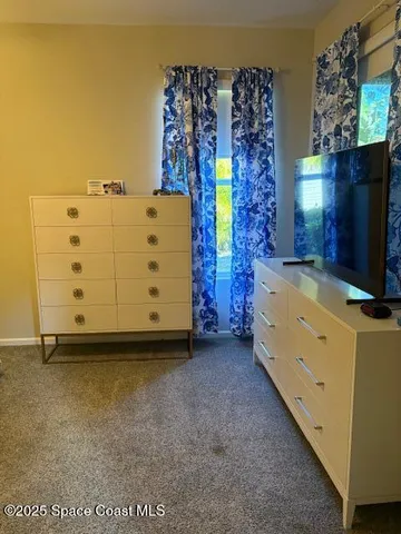 a view of a bedroom with bed and a flat screen tv