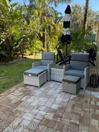 a view of a couches in the patio with a small yard